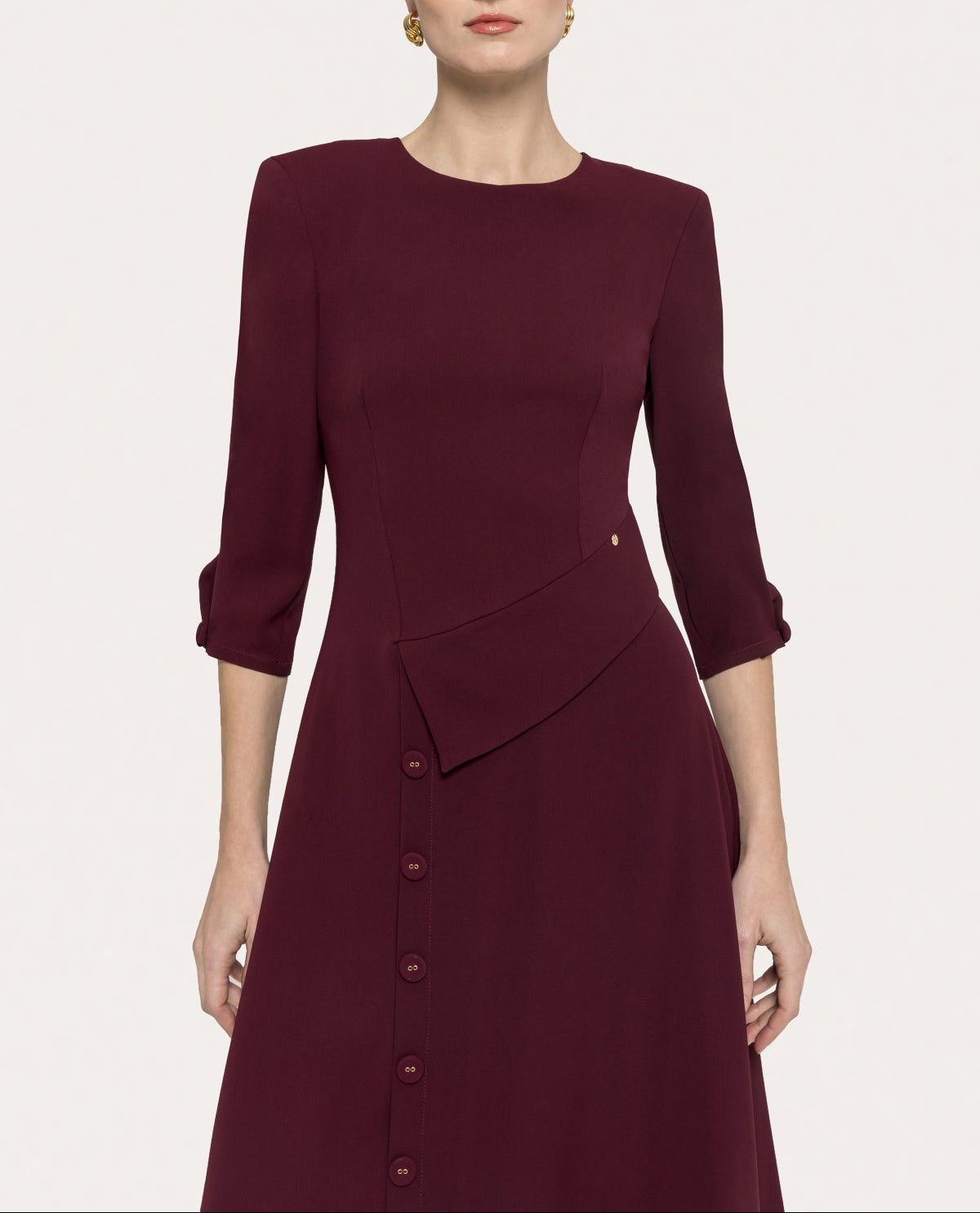 Upper front view of bordeaux button-detail midi dress with structured shoulders and asymmetric waist panel