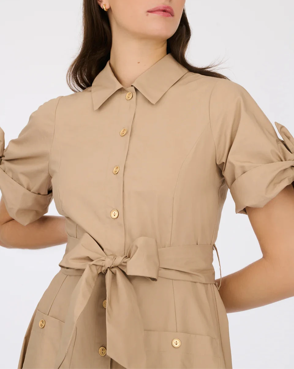 Close-up of beige cotton shirt dress with pointed collar, gold-tone buttons and self-tie waist belt