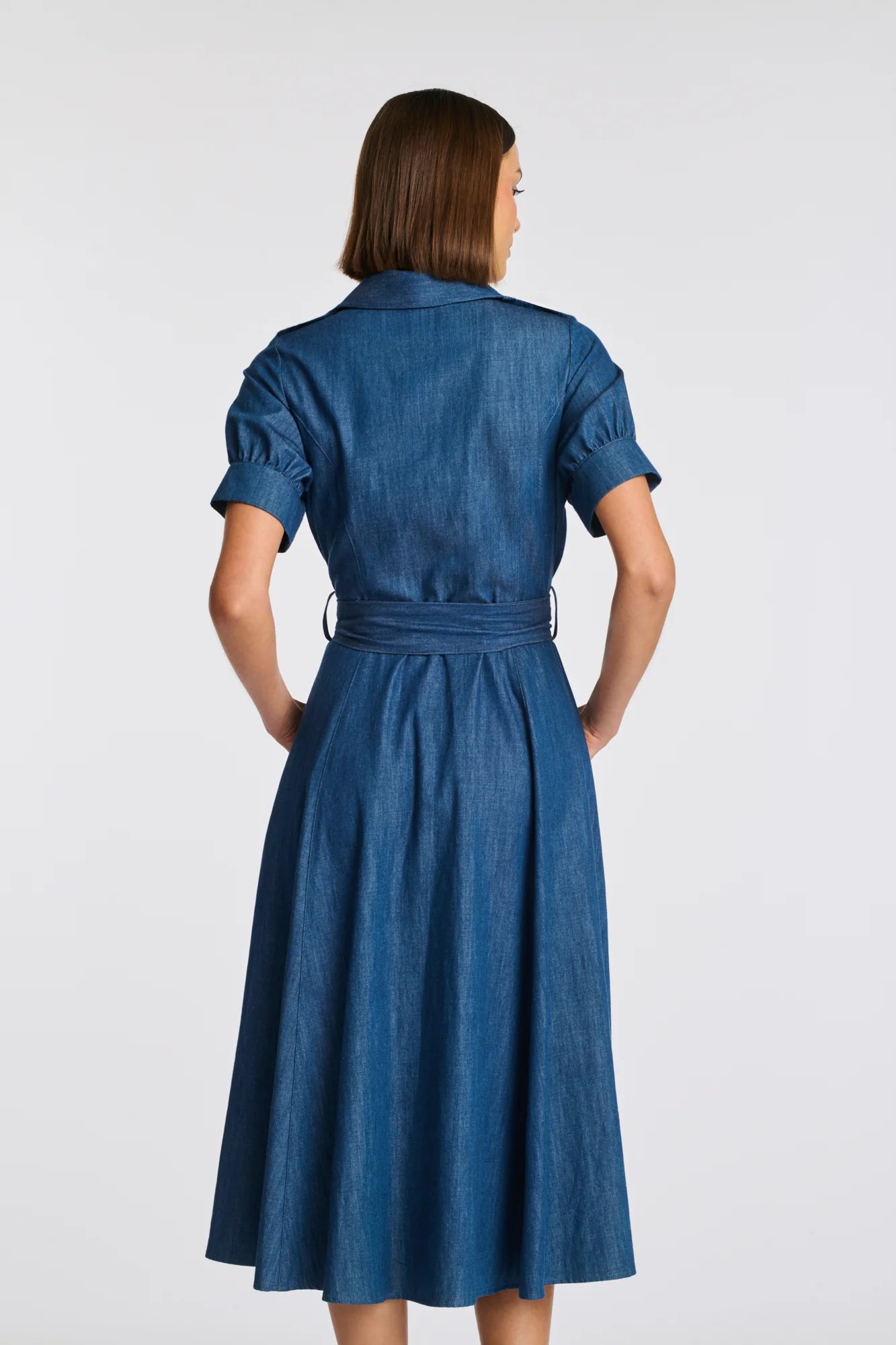 Back view blue denim shirt midi dress with belt and calf-length flared skirt