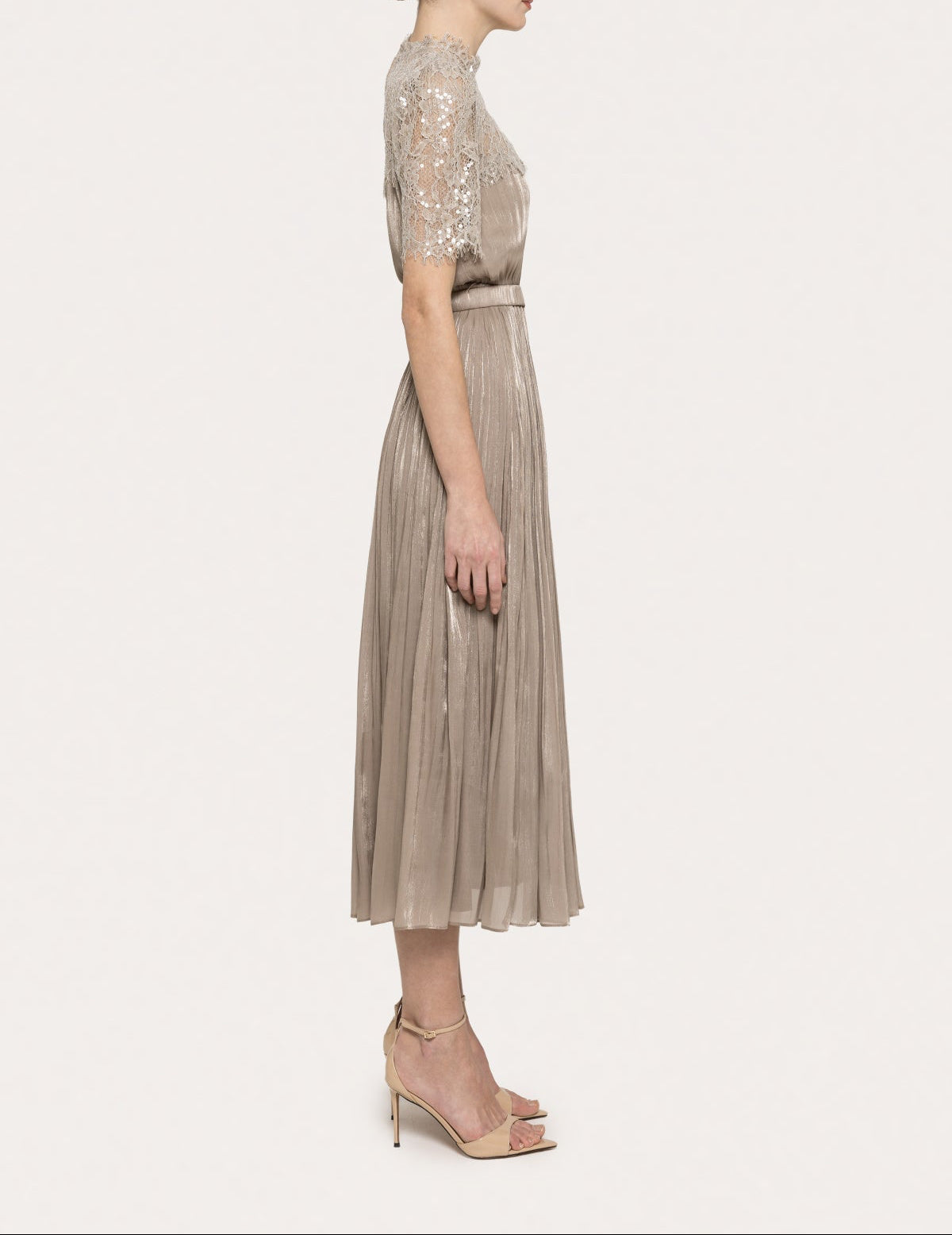 Side view of a champagne metallic pleated midi dress with lace bodice and belted waist