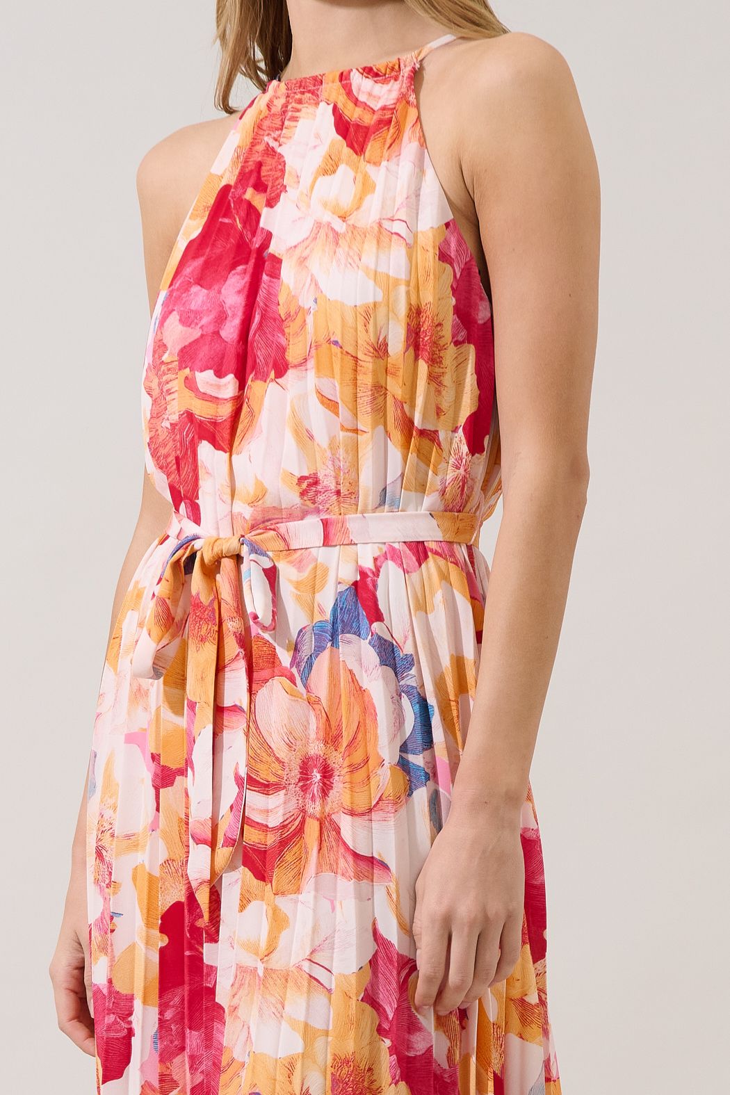 Close-up of Maly dress showing the gathered halter neckline, colorful floral pleats and matching waist tie
