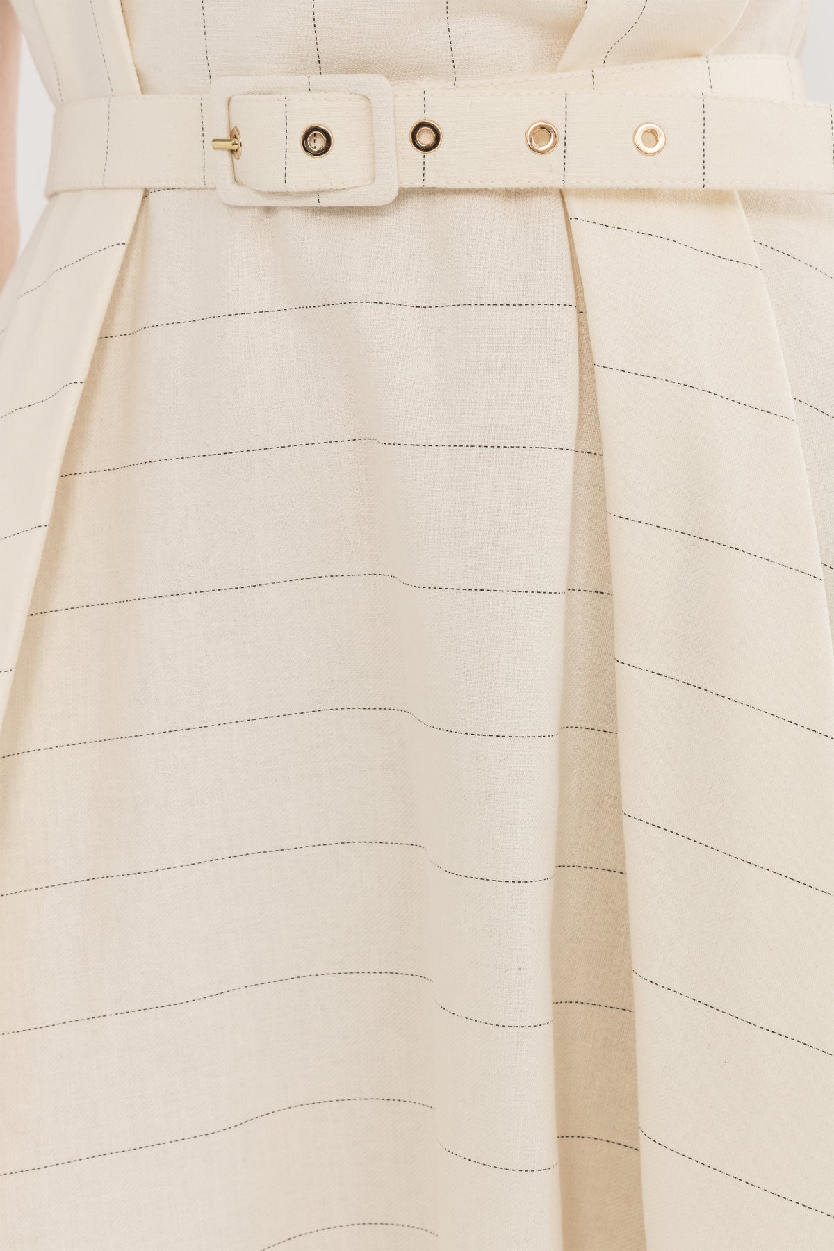 Close-up of the matching belt and subtle pinstripe fabric on an ivory midi dress