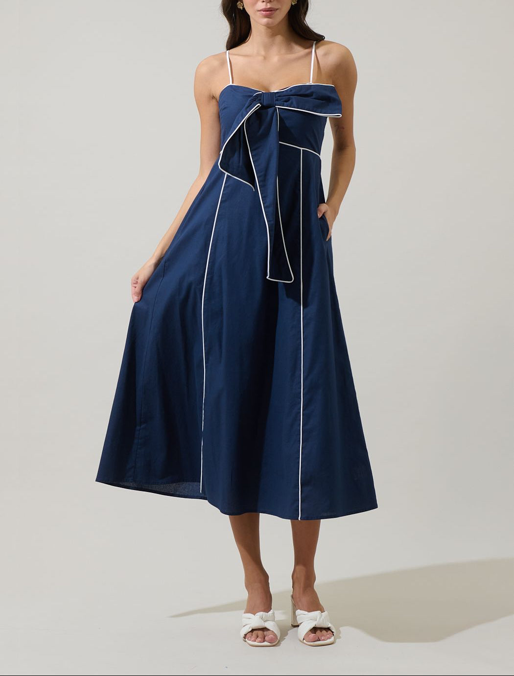 Sugarlips Viona navy and white bow-front empire midi dress with a sweetheart neckline, contrast piping, A-line skirt and pockets.