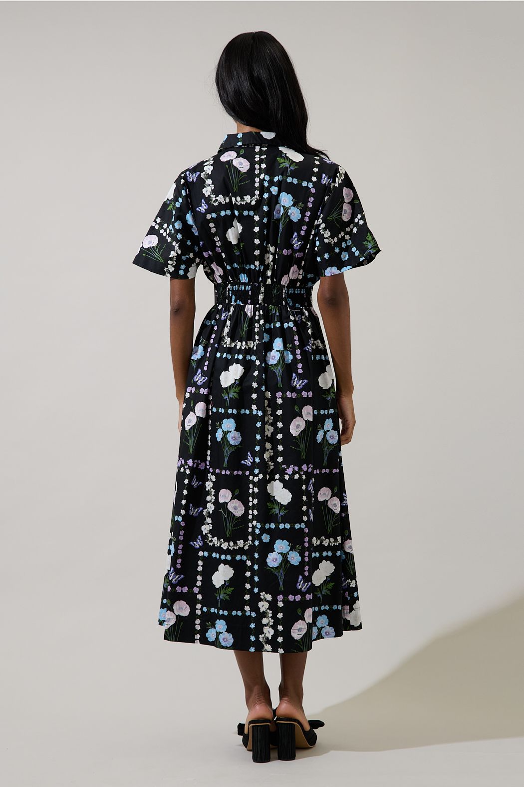 Back view of Wilderra black floral midi dress showing smocked waist, short sleeves and A-line skirt