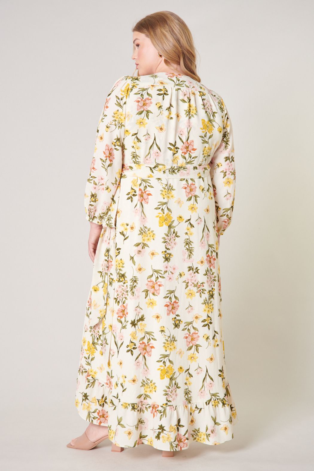 Back view of plus size pastel floral maxi dress with long sleeves and full skirt