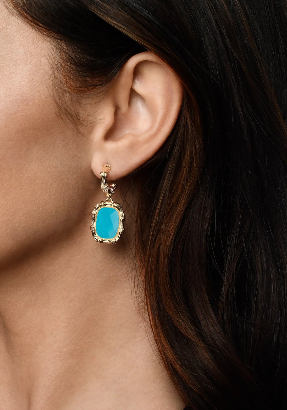 Woman wearing gold bamboo statement earrings