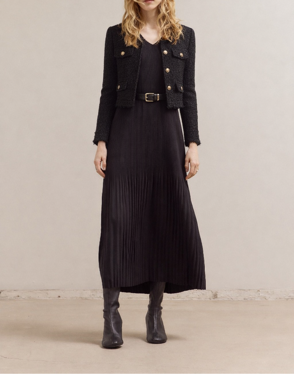Woman wearing a black Wrinkled Pleat Sleeveless Maxi Dress outfit with a black buttoned with pocket tweed jacket against a plain background