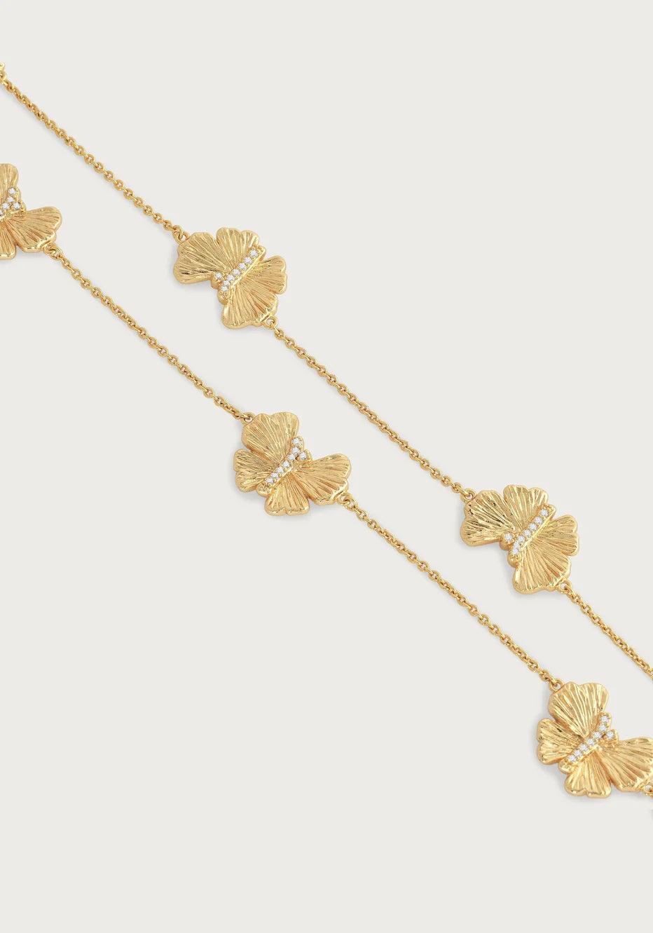 Close-up of butterfly charms on gold station necklace chain