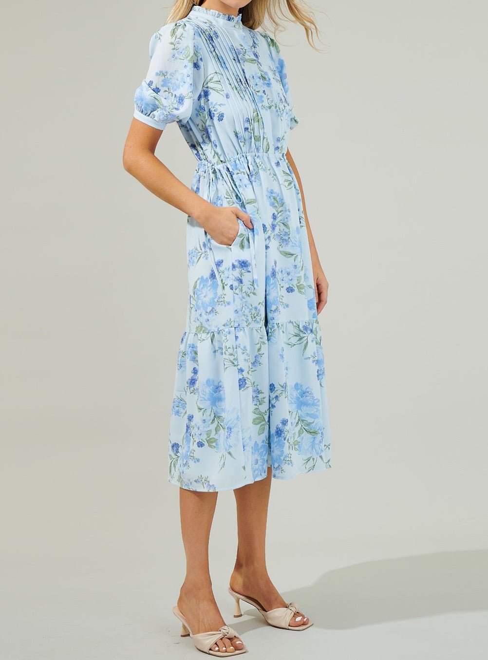 Side view of light blue floral midi dress with drawstring waist and flowing skirt