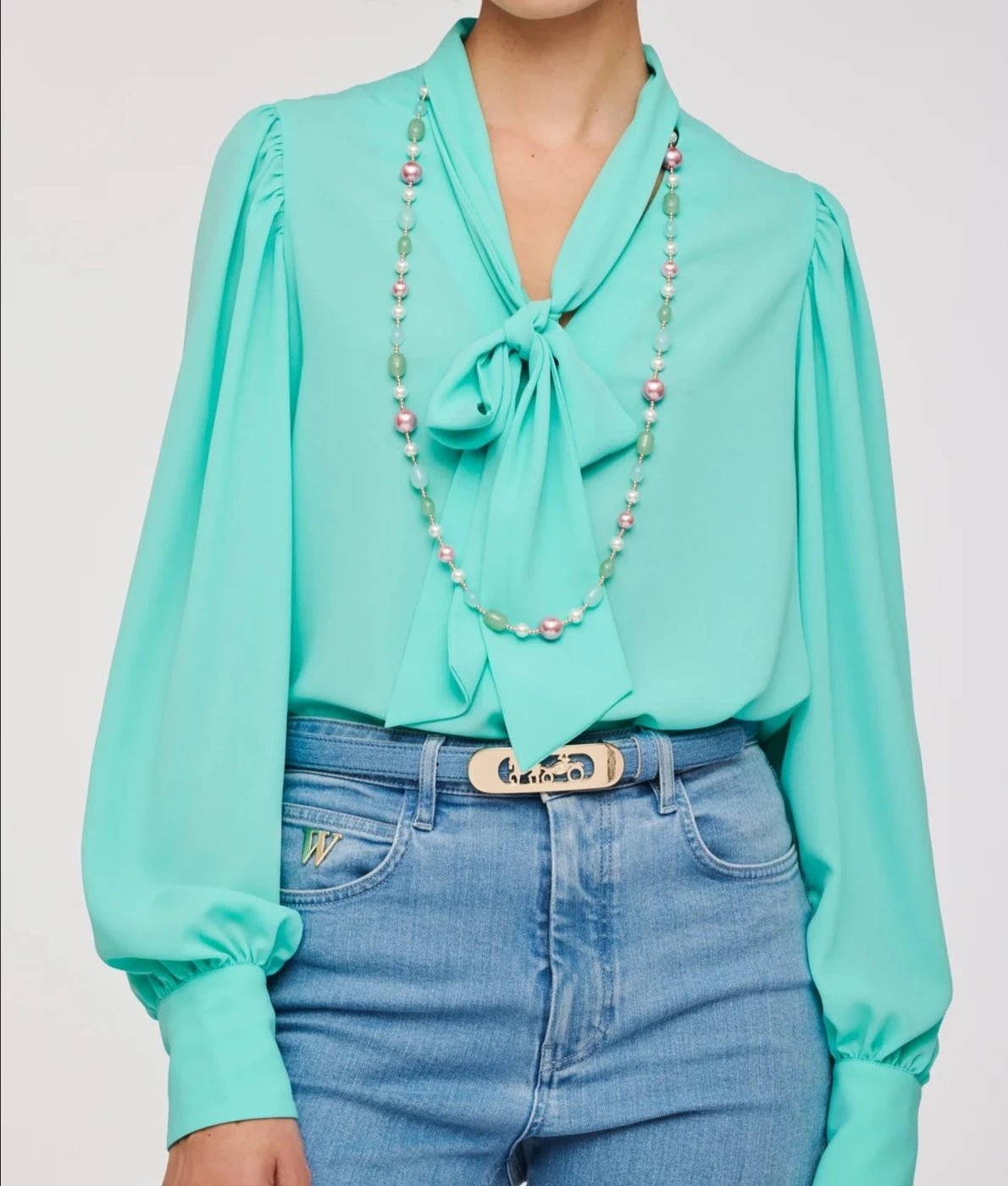 Close-up of Weill Paris pastel pearl bead long necklace with mint, blush, and pearl tones on an aqua tie-neck blouse