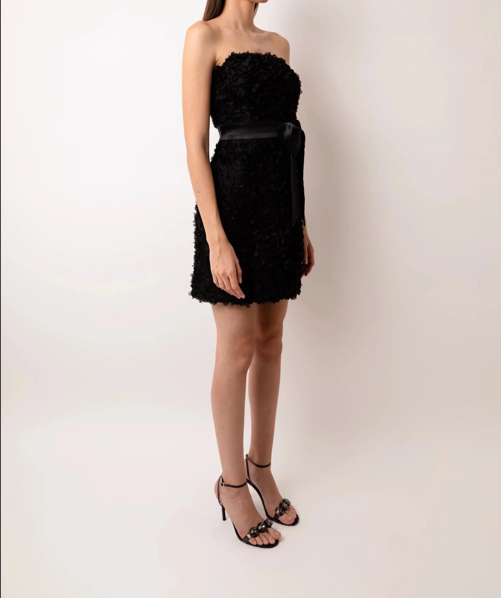 Black strapless cocktail mini dress with floral textured fabric and satin bow waist