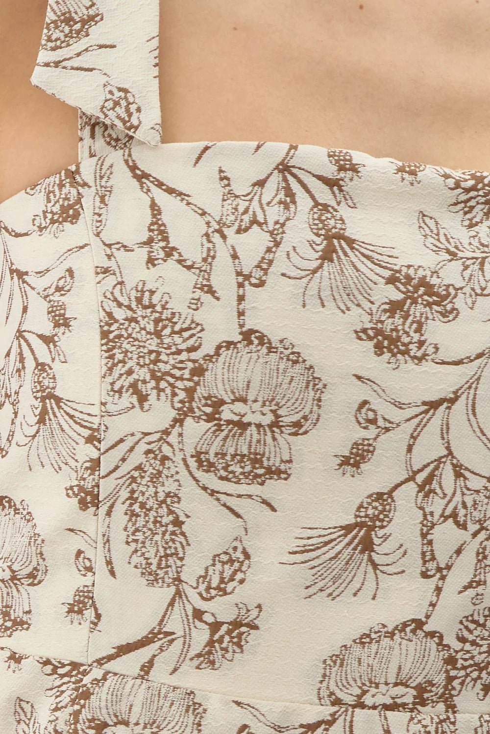 Detail close-up of cream and mocha botanical floral jacquard fabric and square neckline