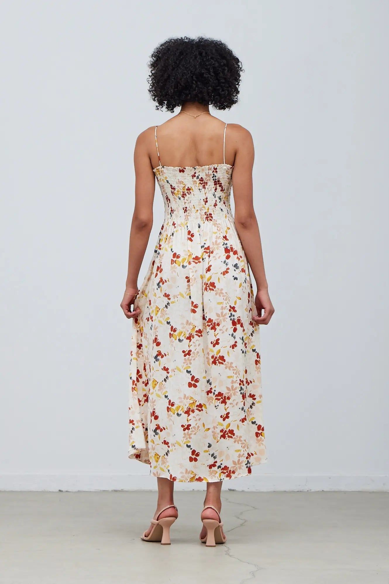 Back view of cream floral smocked bodice midi dress by Grade & Gather with adjustable spaghetti straps