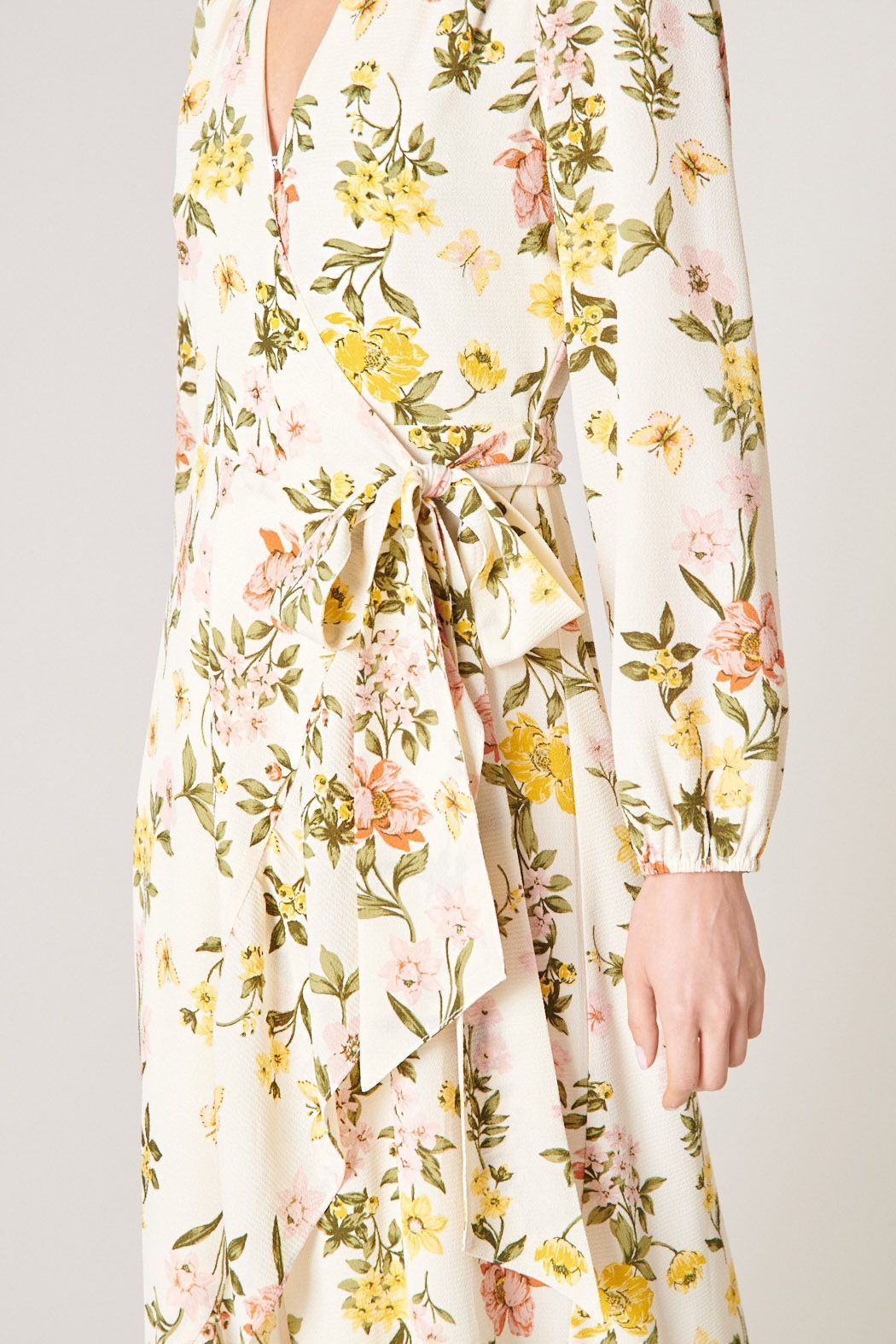 Back view of ivory floral maxi dress with long sleeves and flowing ruffle hem