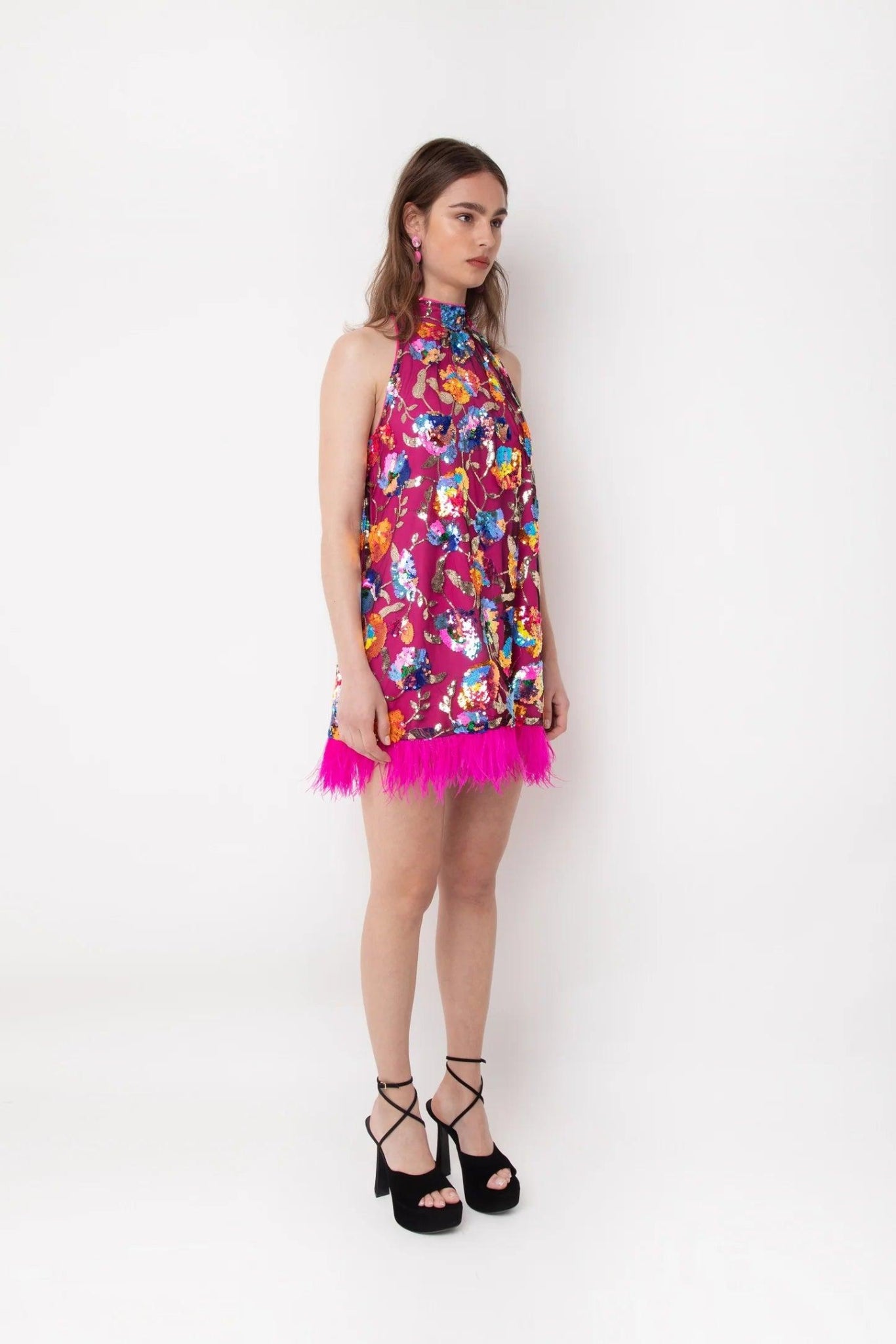 Side view of pink floral sequin feather trim mini dress with sleeveless high-neck silhouette