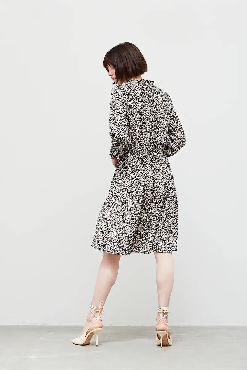 Back angled view of black floral print knee-length dress