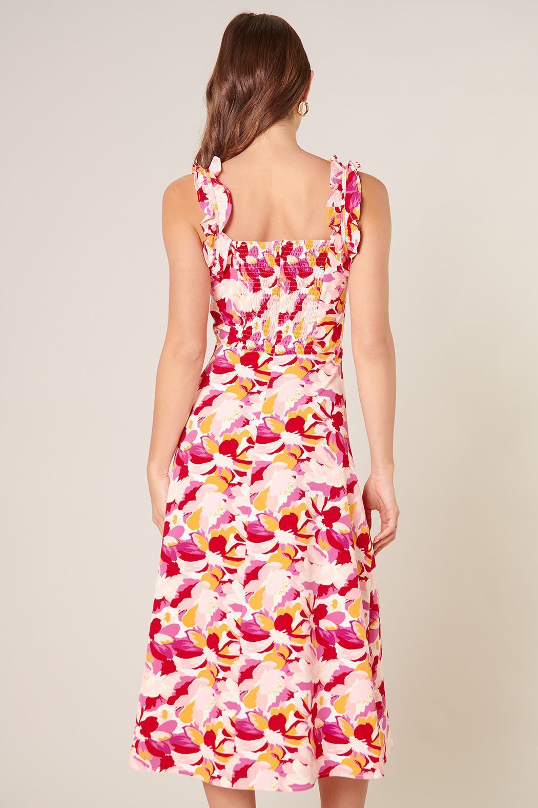 Back view of pink floral midi dress with smocked back and ruffle straps
