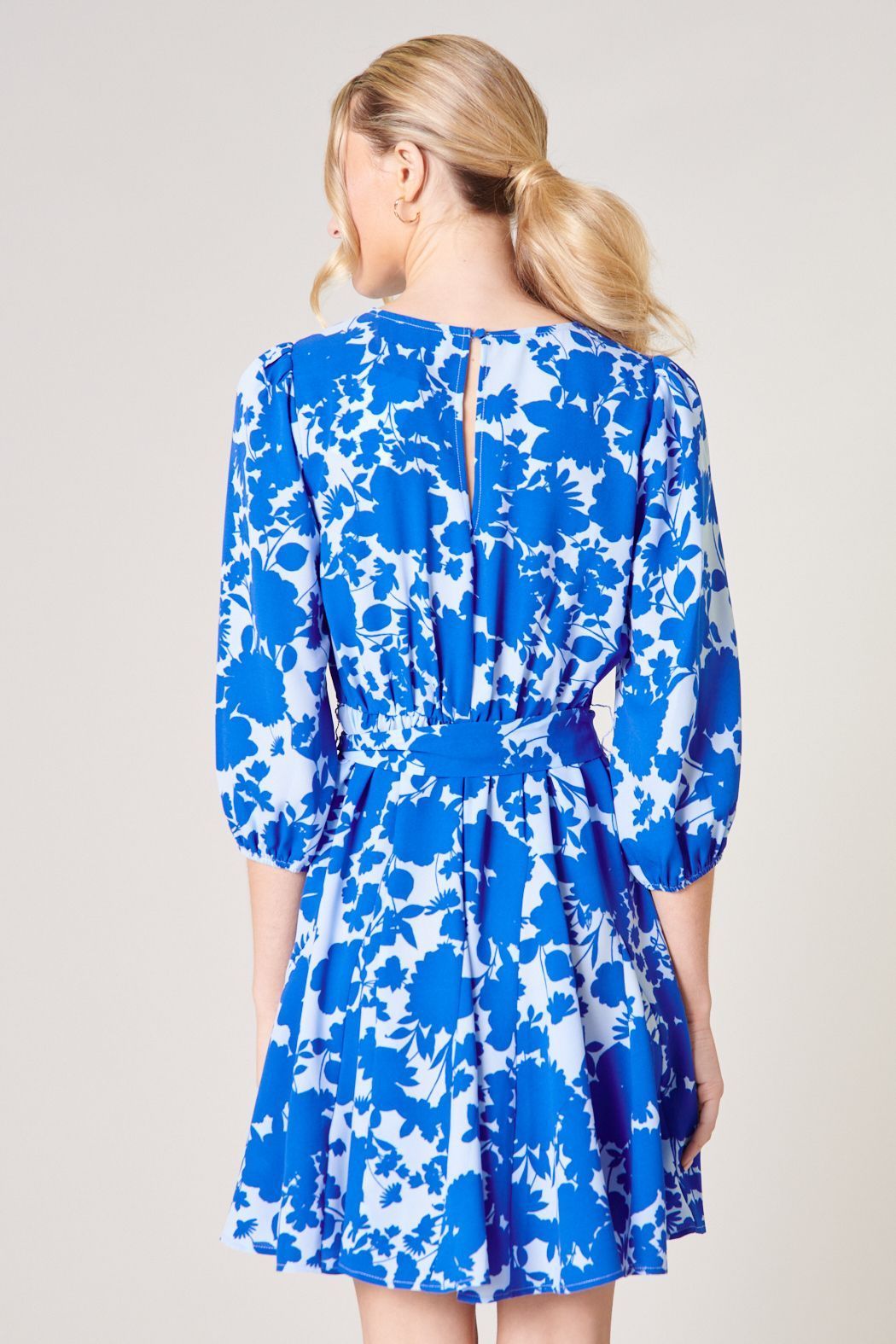 Back view of blue floral mini dress with keyhole back and tie waist