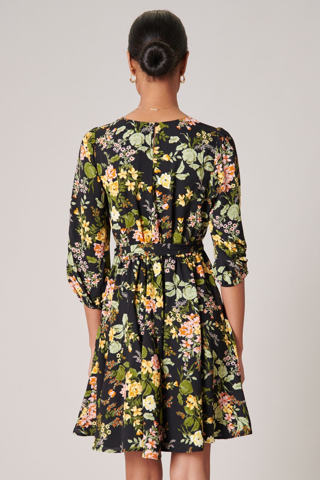 Back view of black floral mini dress with keyhole back and tie waist