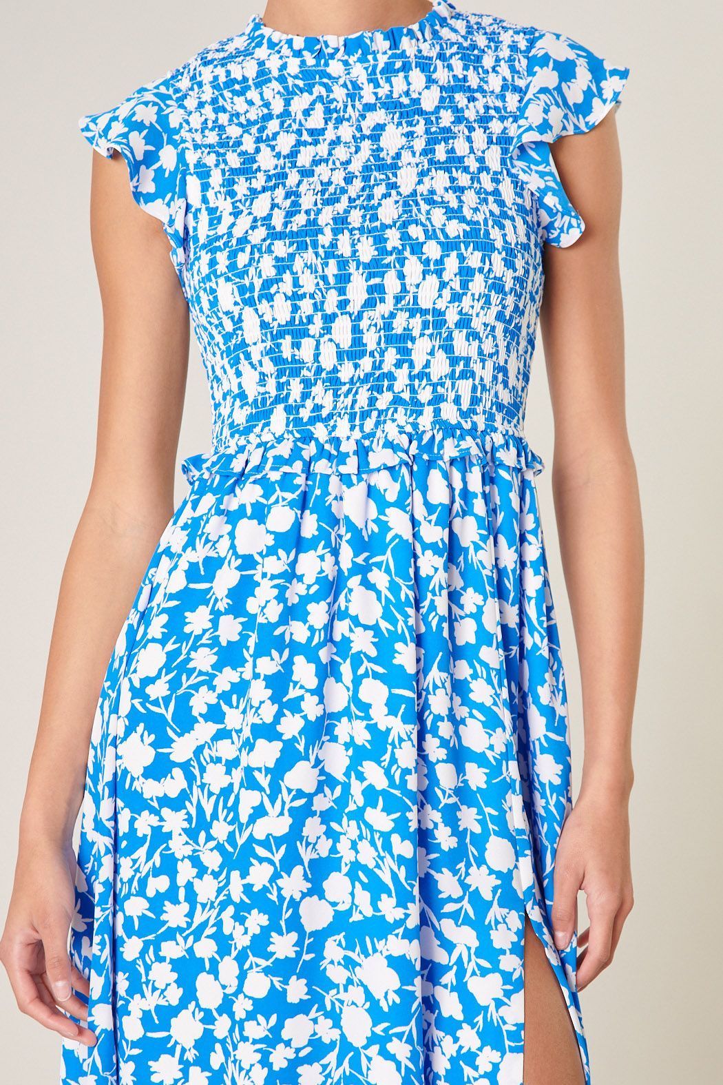 Close-up of smocked bodice and blue print on ivory midi dress