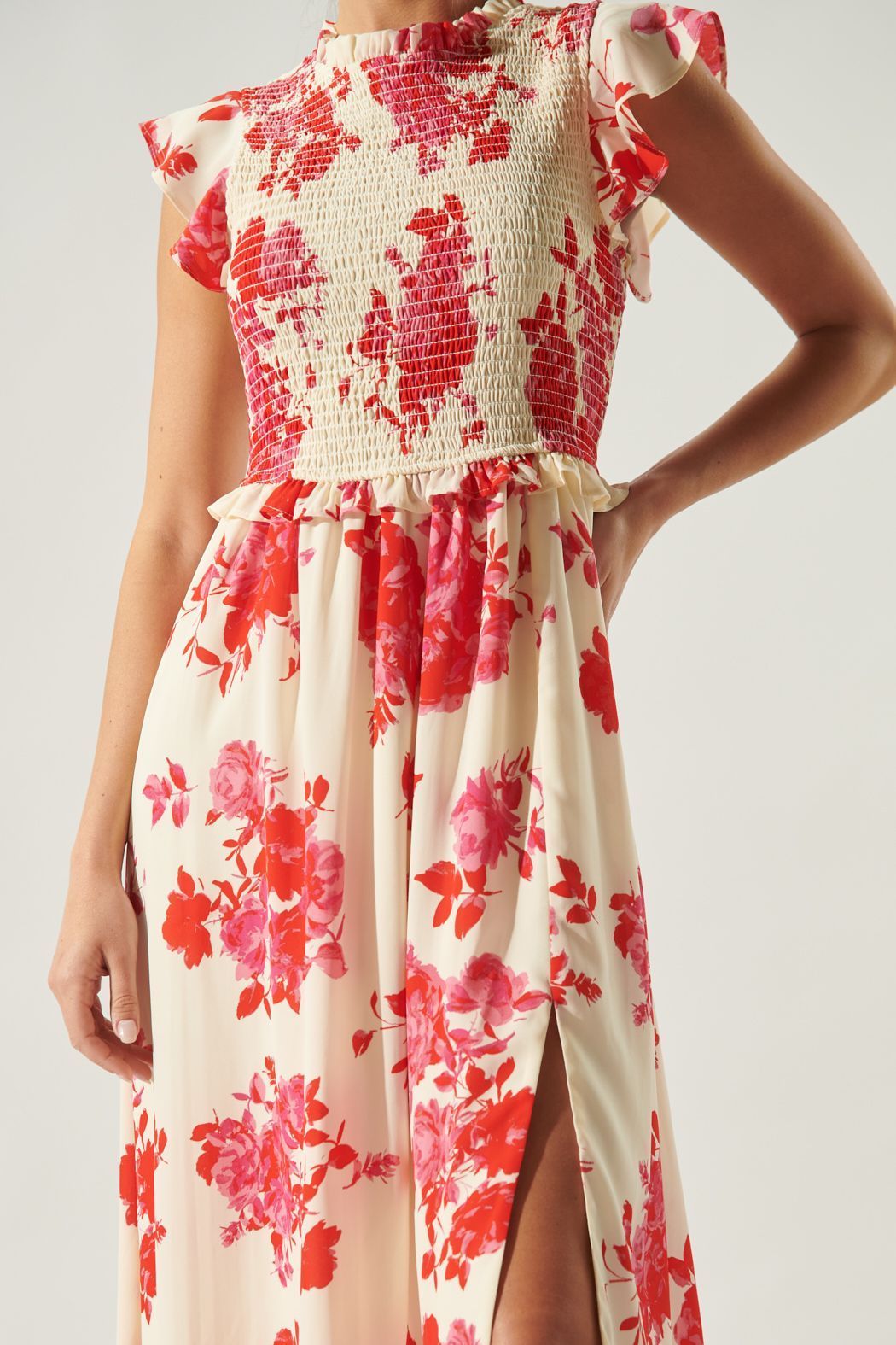 Close-up of smocked bodice, ruffle neckline, and crimson floral print on midi dress