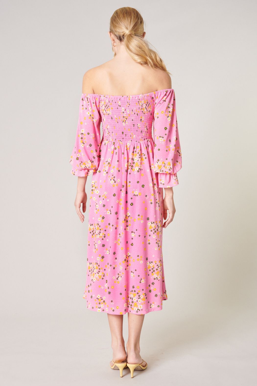 Back view of pink floral off-shoulder midi dress with smocked back bodice