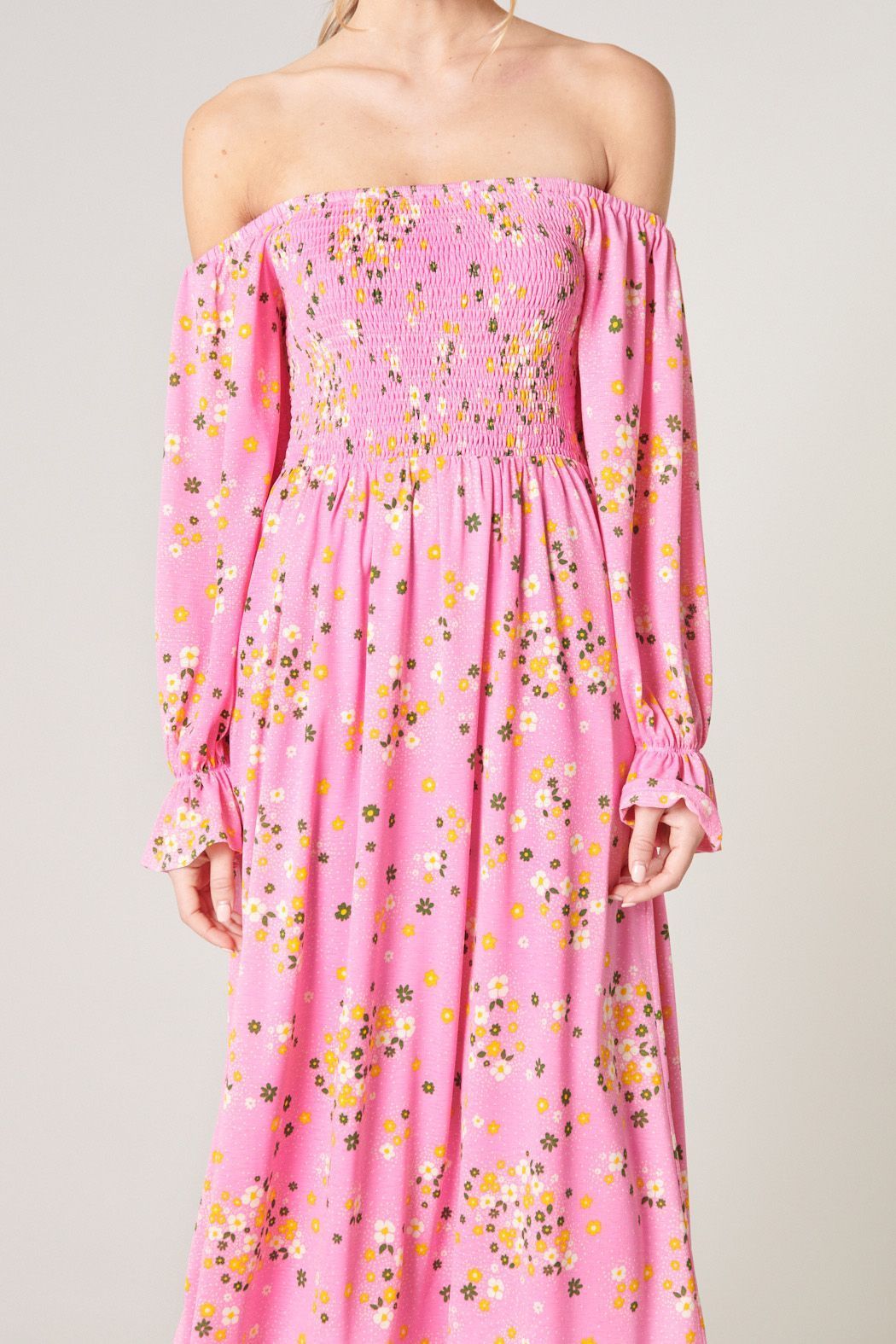 Close-up of smocked bodice, off-shoulder neckline, and pink floral print on midi dress