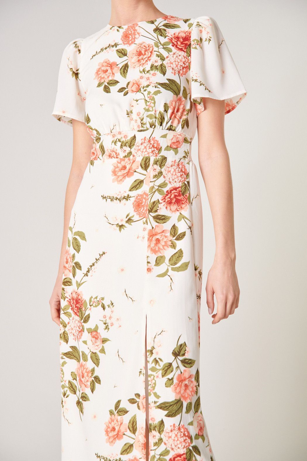 Close-up of ivory floral midi dress with flutter sleeves, round neckline, and front slit