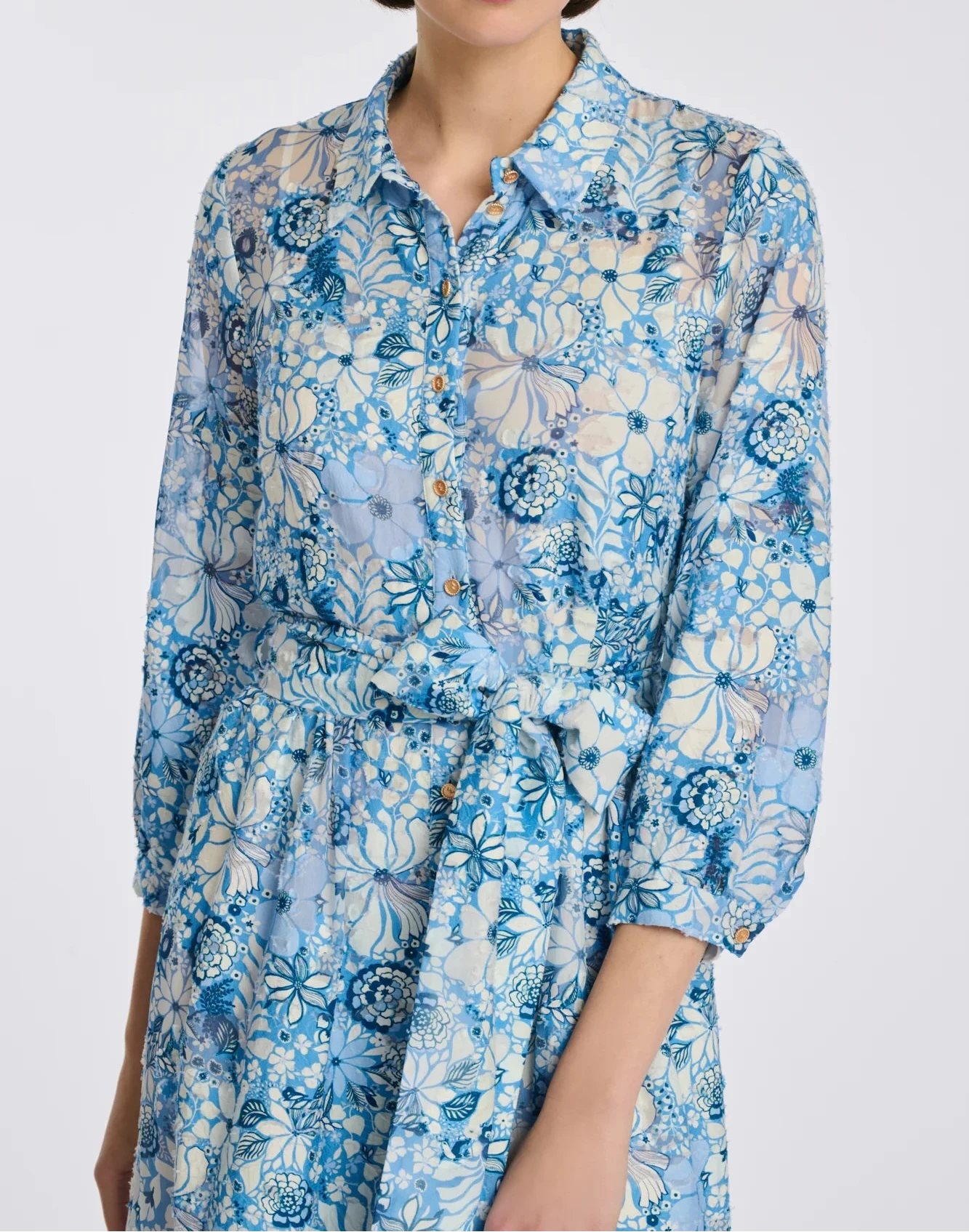 Close-up of blue floral midi shirt dress with shirt collar, gold buttons, and 3/4 sleeves