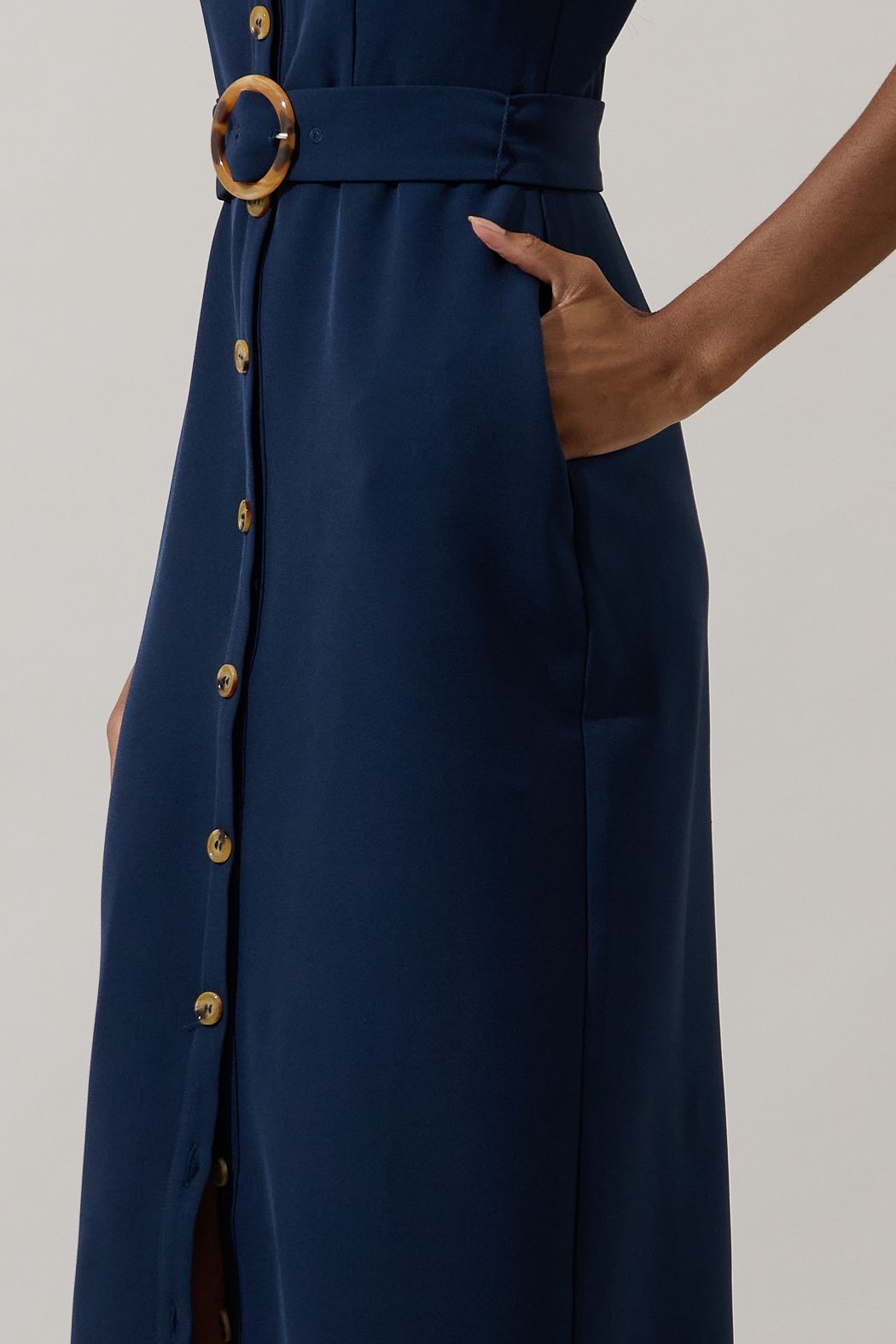 Close-up of dark navy midi dress with button-front detail, belt, and side pocket
