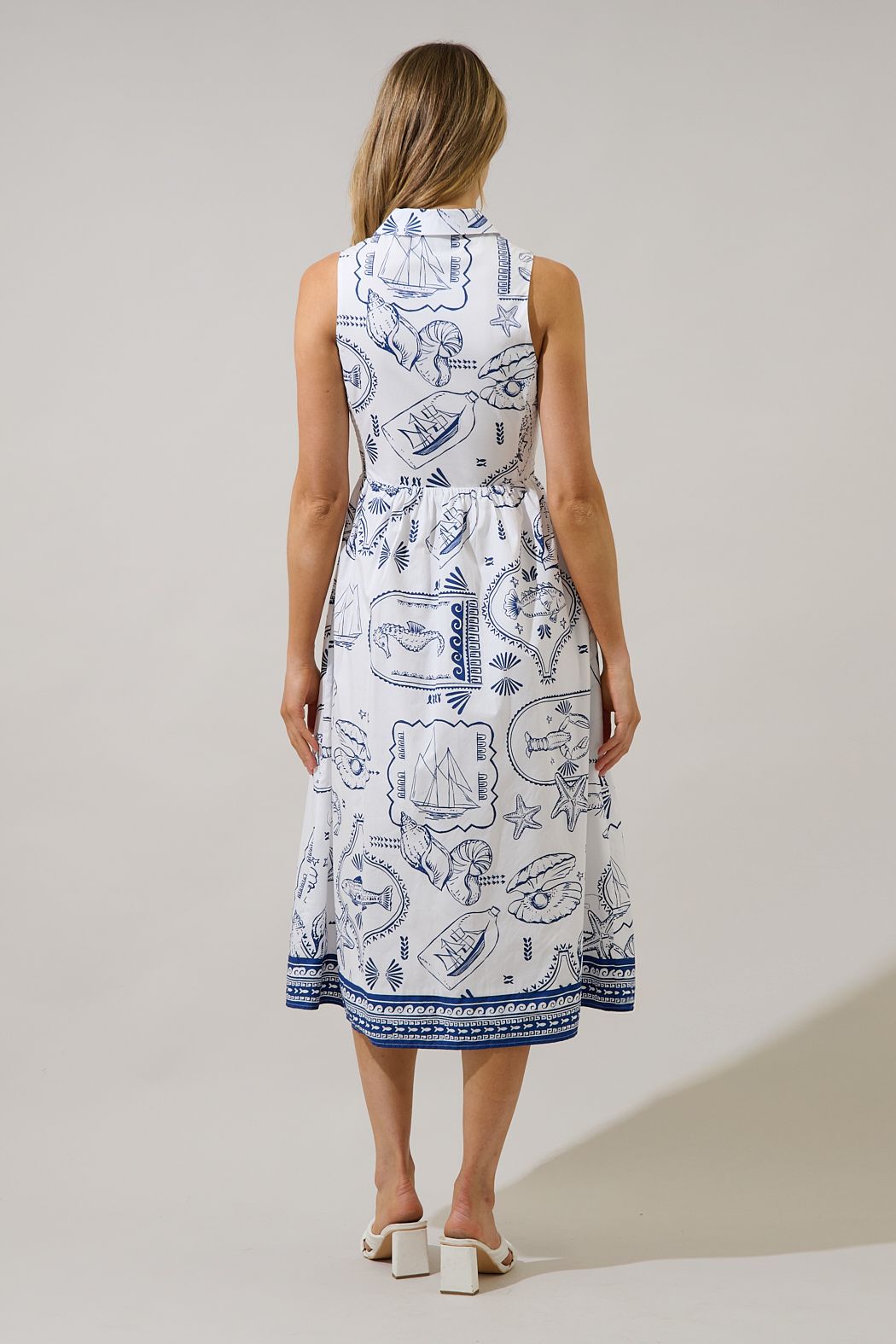 Back view of blue and white sleeveless collared A-line midi dress with seaside print