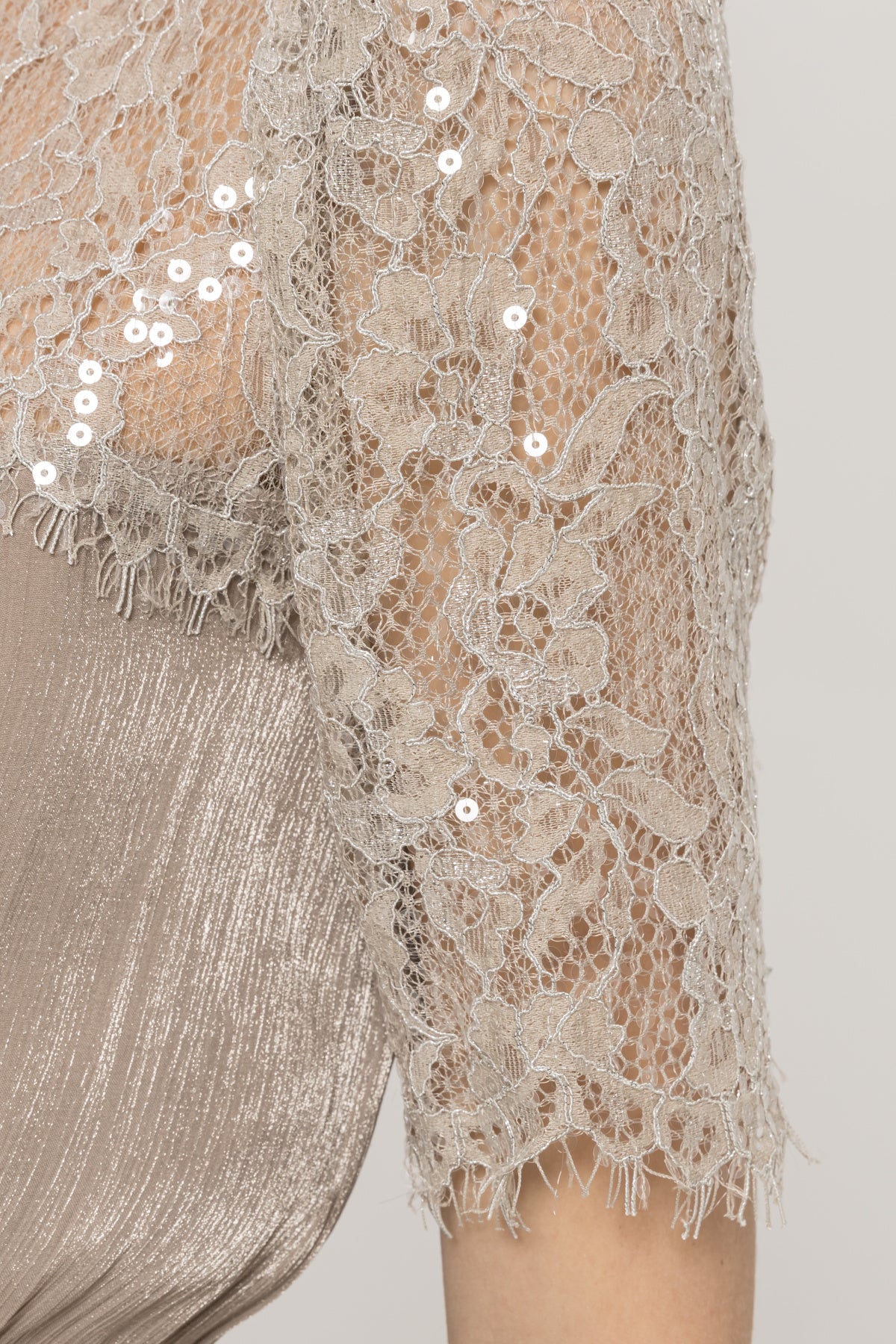 Close-up of champagne floral lace elbow-length sleeve with sequin detail on a champagne midi dress