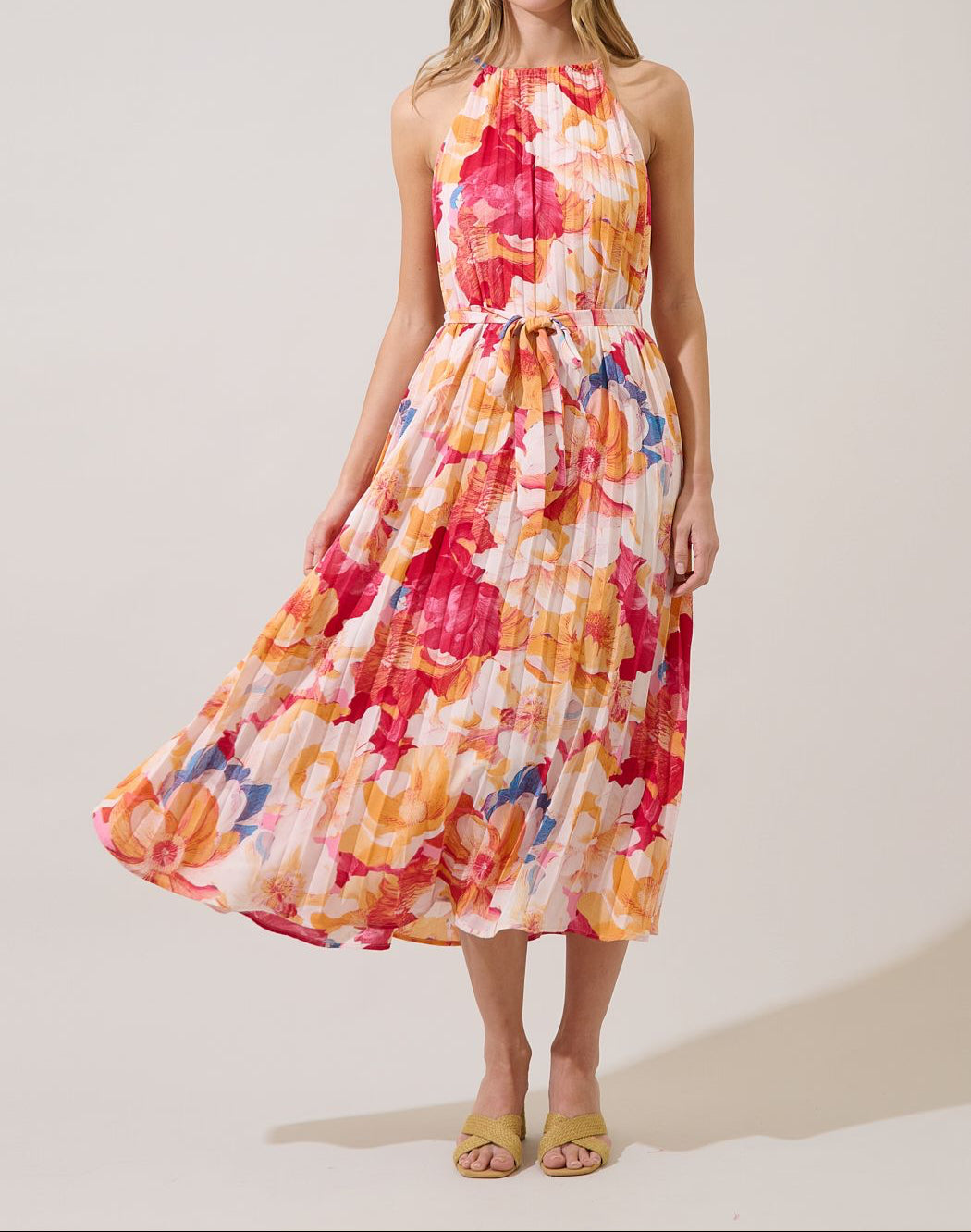 Front view of Maly coral multicolor floral pleated halter midi dress with matching self-tie belt