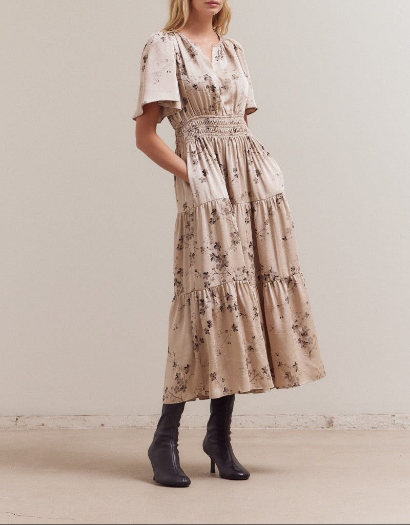 Front angled view of natural floral tiered midi dress with flutter sleeves
