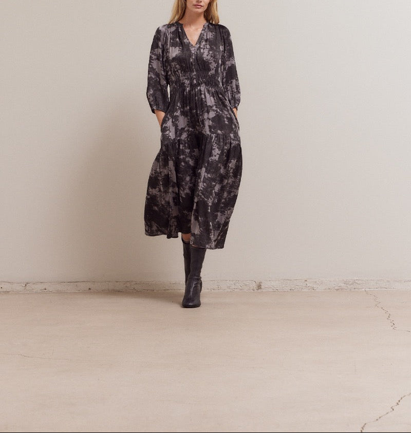 Walking front view of printed midi dress with pockets and smocked waist