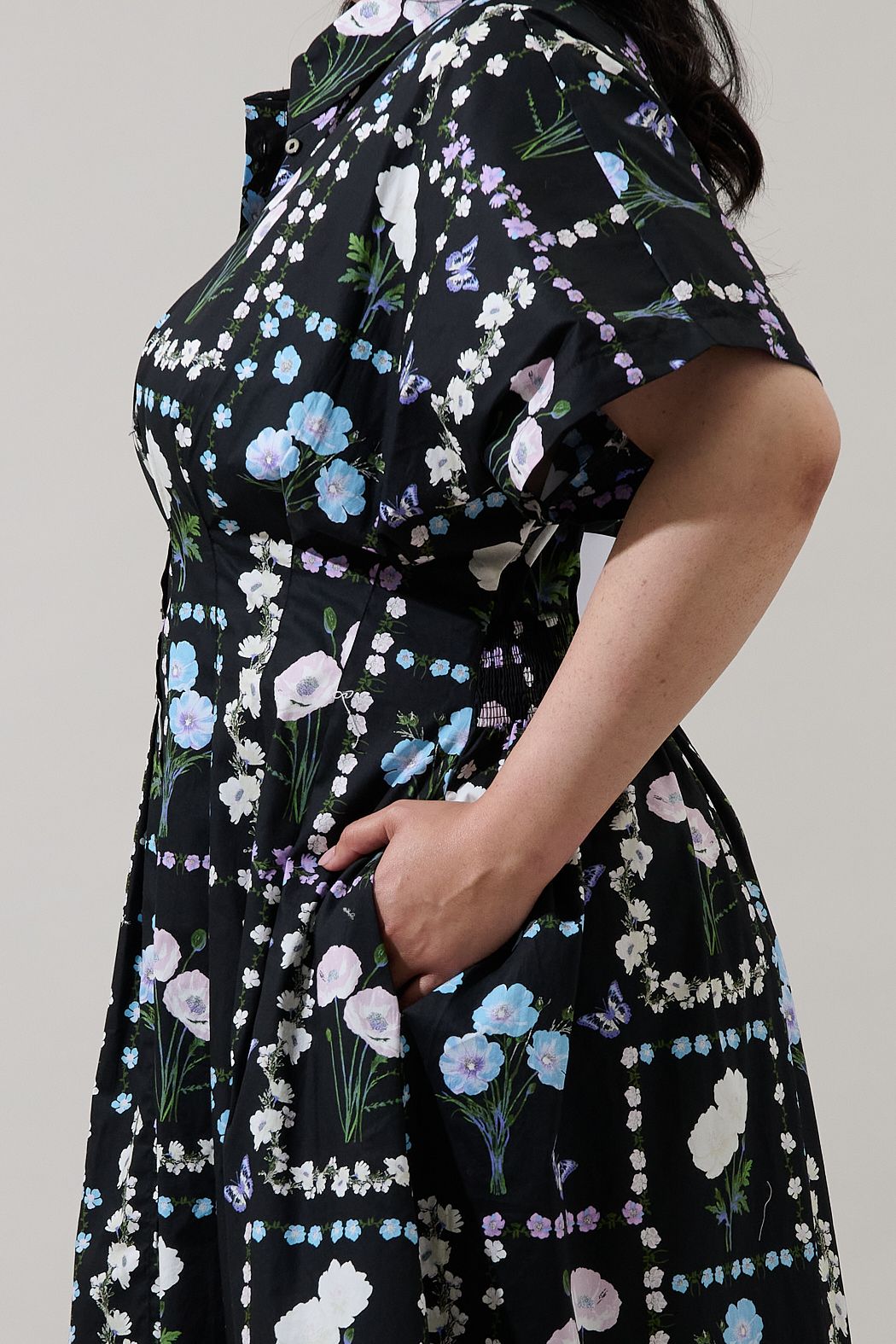 Close-up curve view of Wilderra floral midi dress showing button front, pocket, sleeve and cotton print