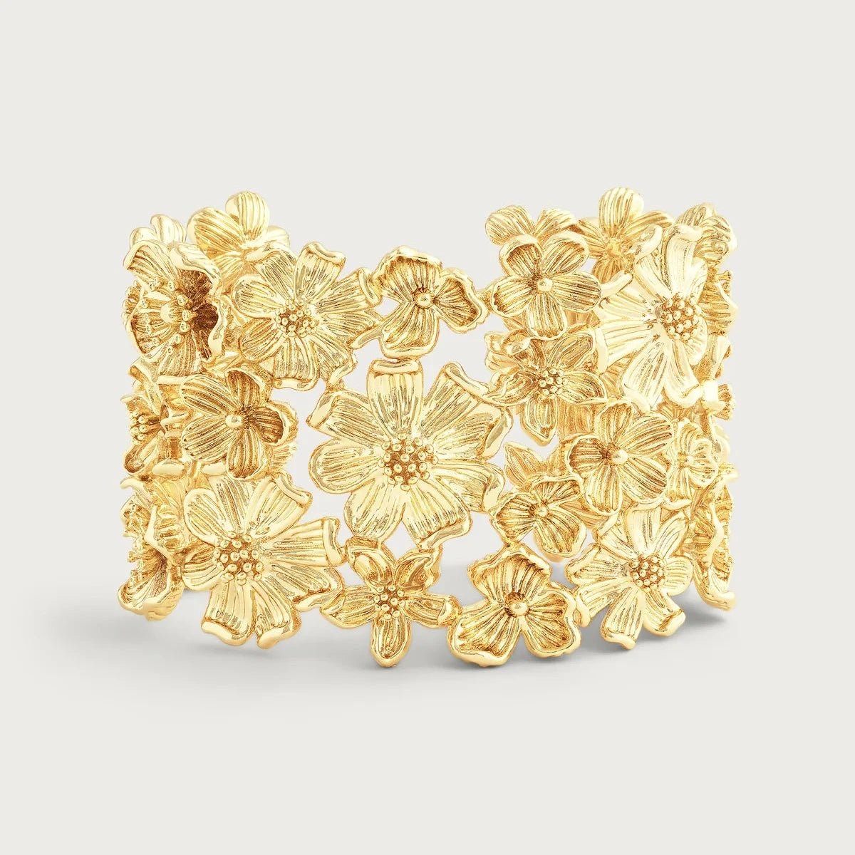 Wildflower‑inspired wide cuff bracelet  with sculpted gold-tone flowers in an open cuff design