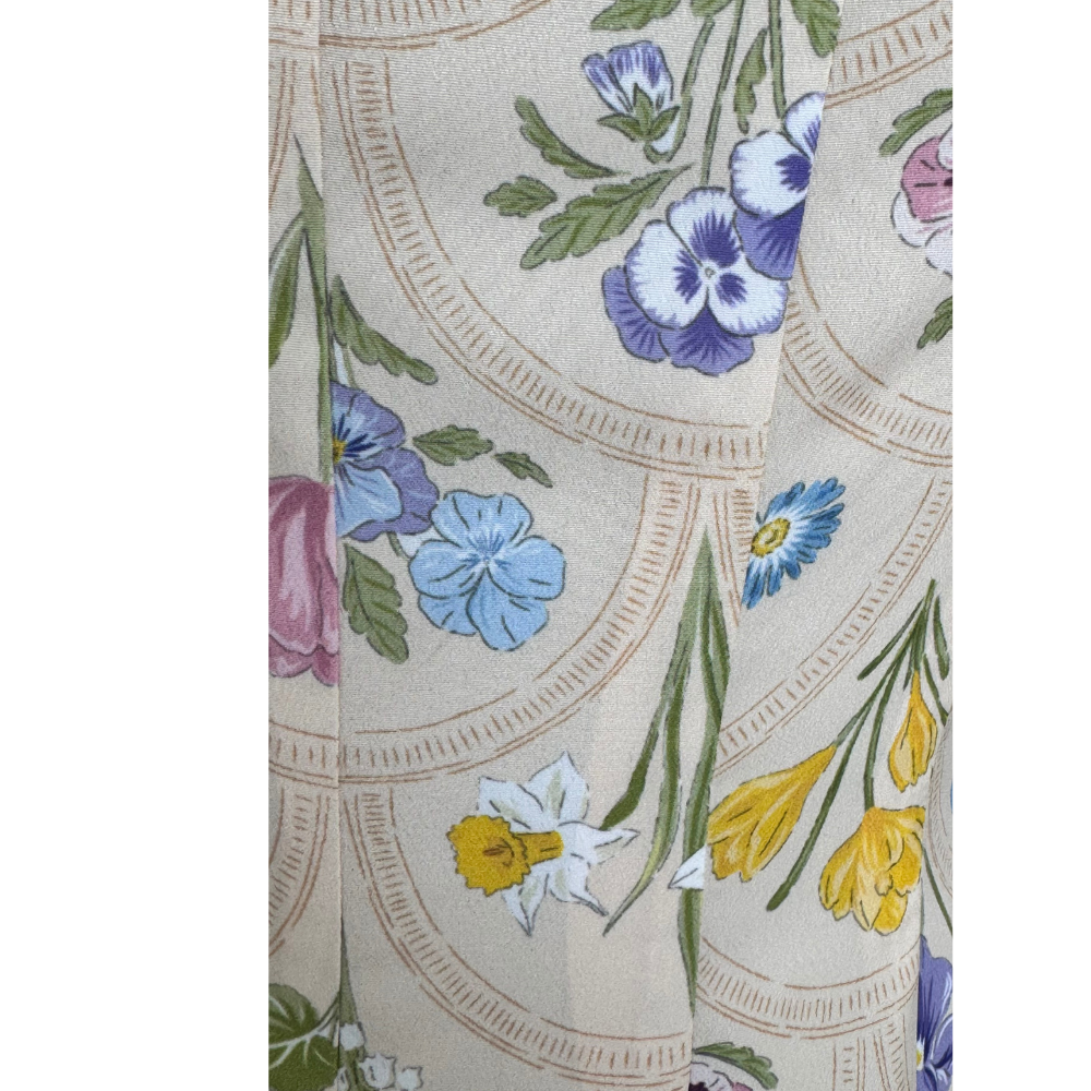 Close-up of cream floral print with yellow, blue, lavender, and green detail on Nora Noh midi dress