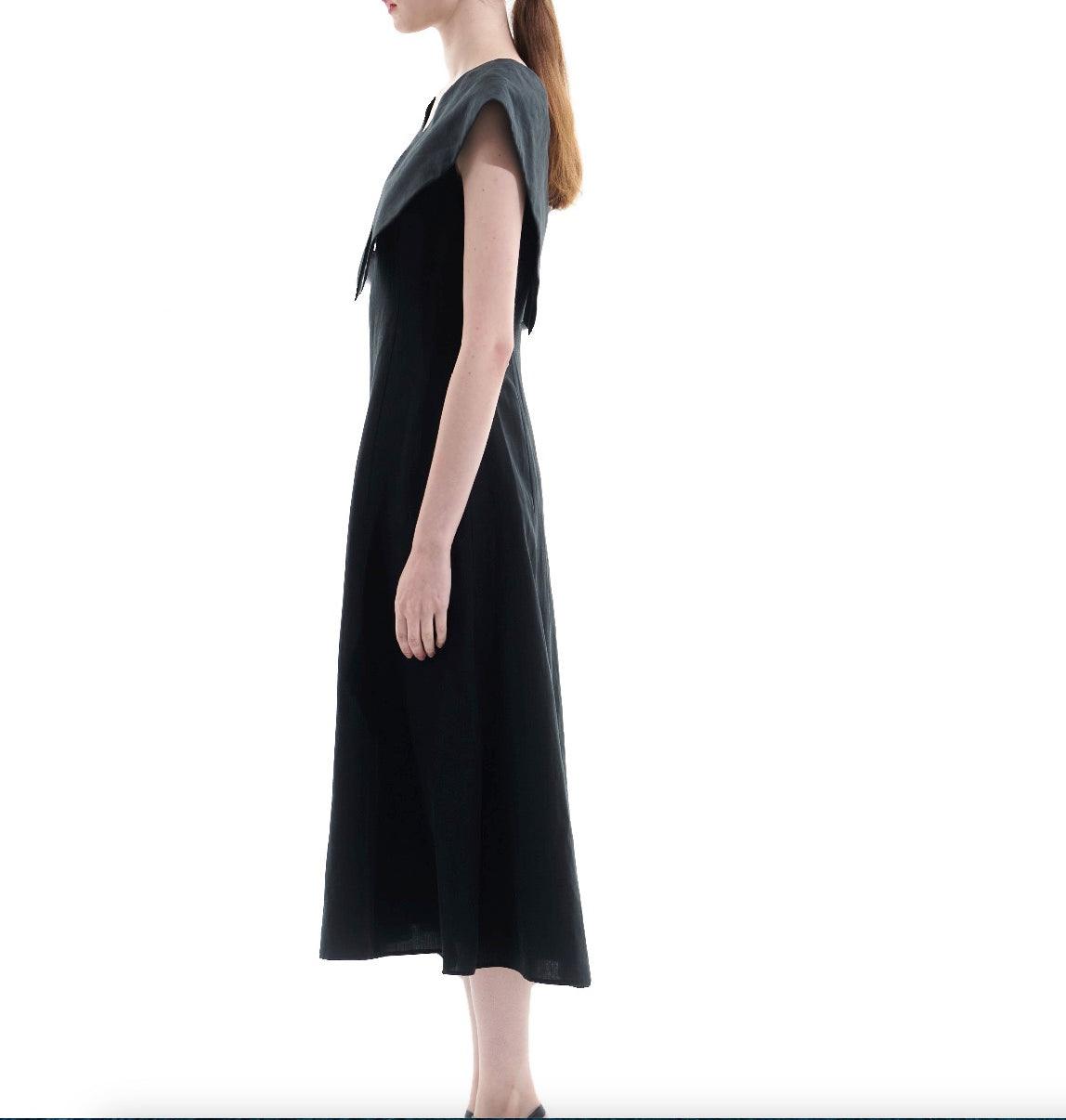 Side view of black A-line midi dress with extended shoulder detail