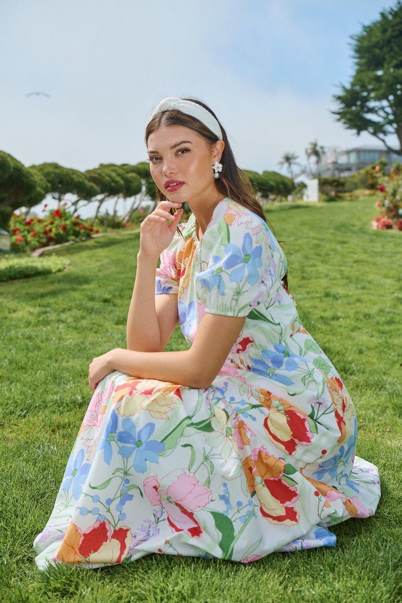 Seated lifestyle view of pastel floral garden maxi dress with puff sleeves