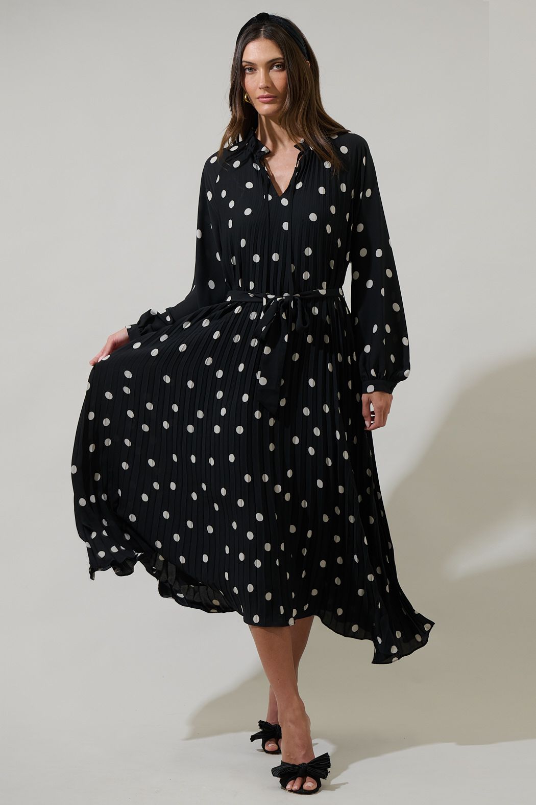 Black polka dot long sleeve pleated midi dress with split neckline and tie waist