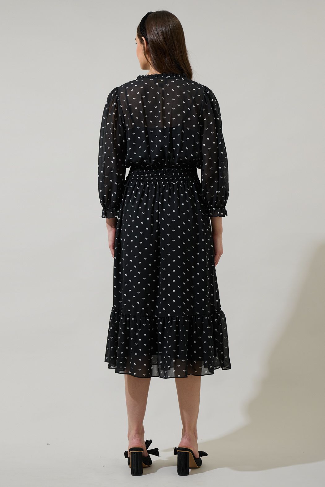 Back view of black bow print midi dress with long sleeves and smocked waist