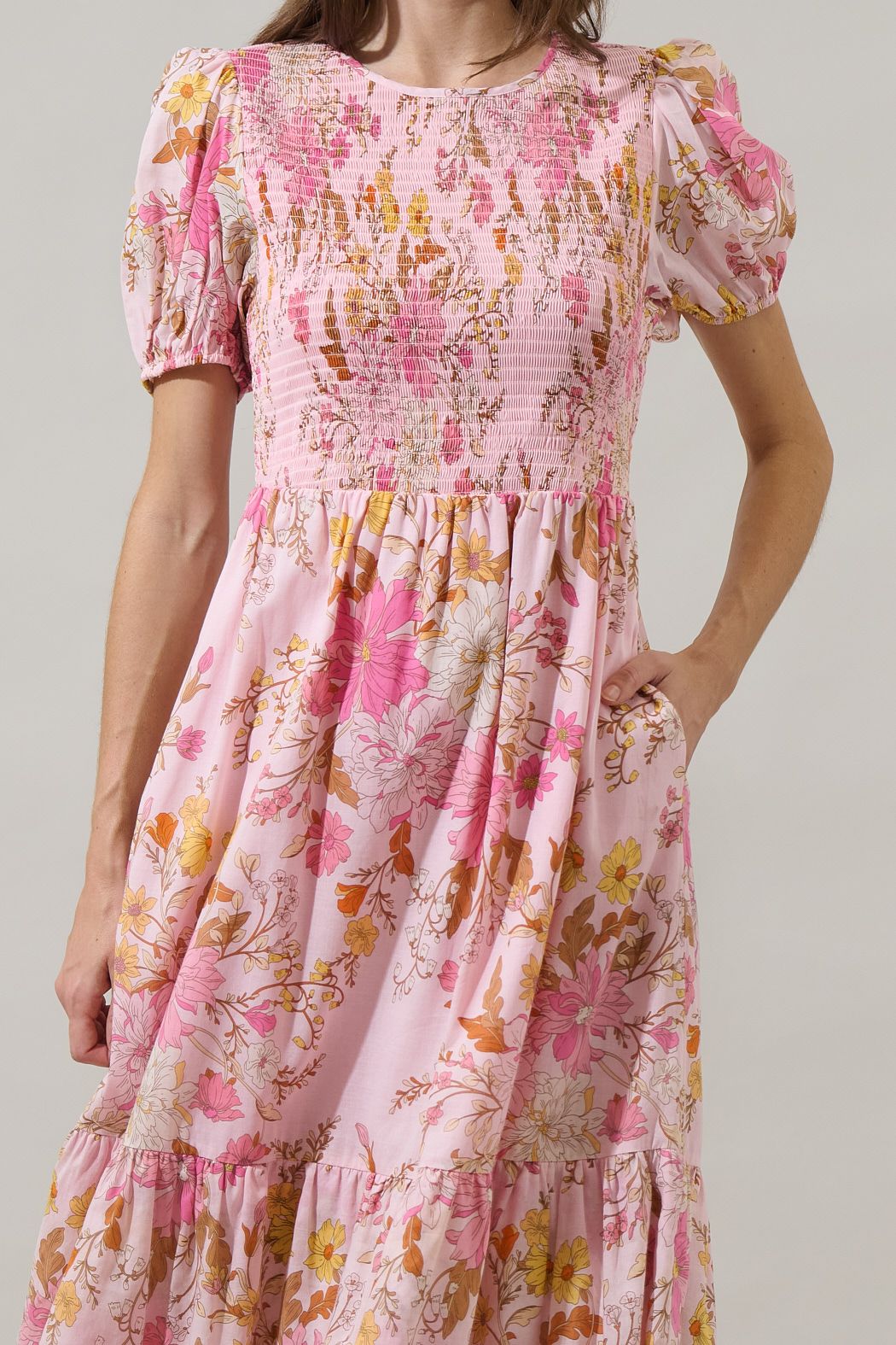 Close-up of pink floral smocked cotton midi dress bodice and pocket detail