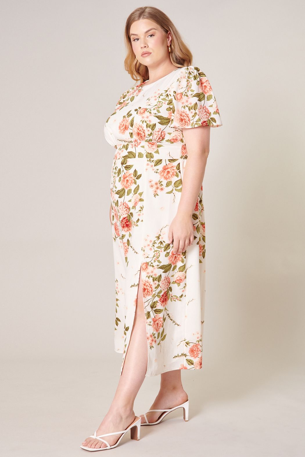Plus size pink floral midi dress with short flutter sleeves and slim midi silhouette