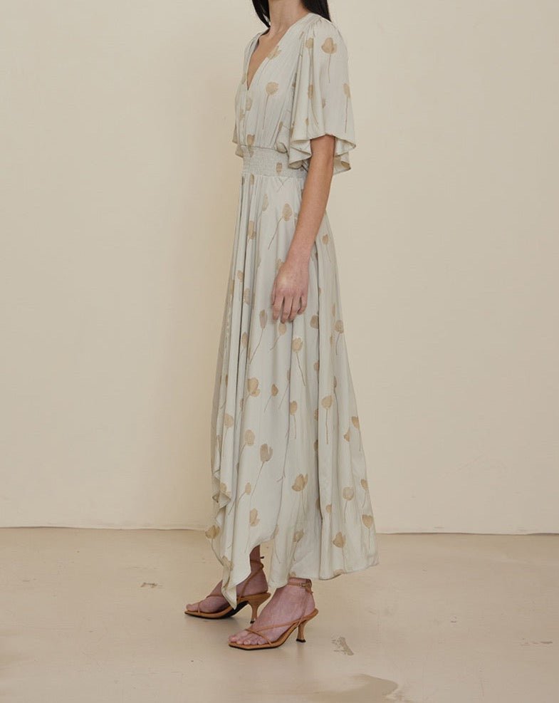 Front angled view of soft blue floral maxi dress with asymmetrical hem