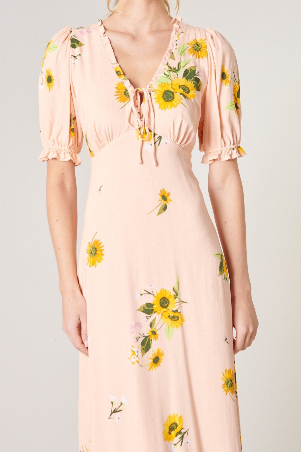 Close-up of yellow floral print and puff sleeve on midi dress