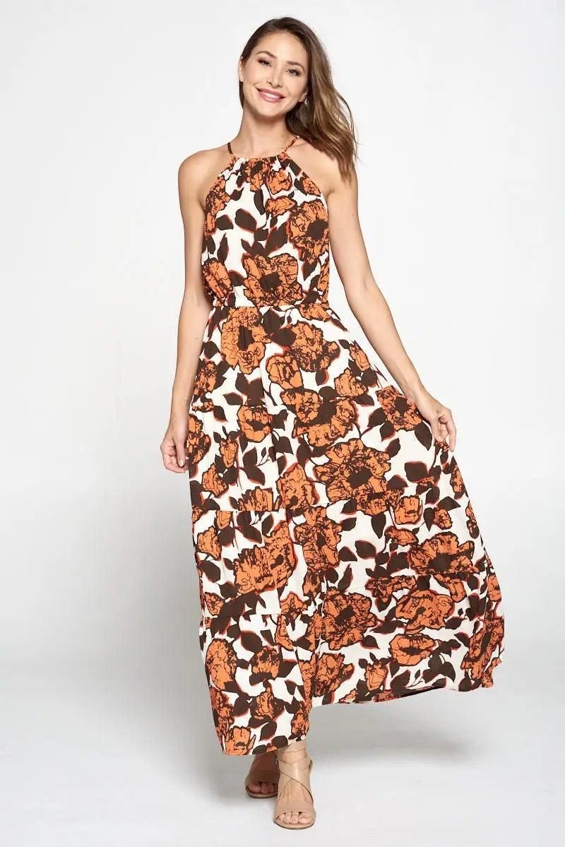 Model wearing Renee C coral ivory floral halter neckline maxi dress