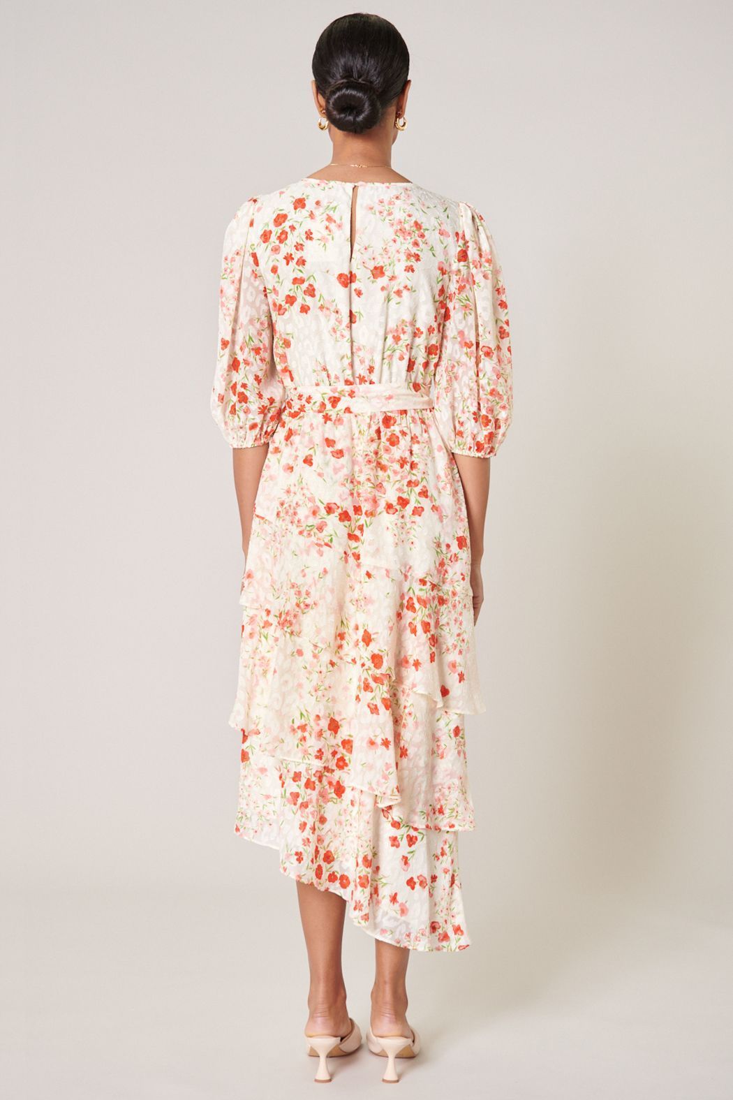 Back view of blush floral ruffle midi dress with keyhole back and sash waist