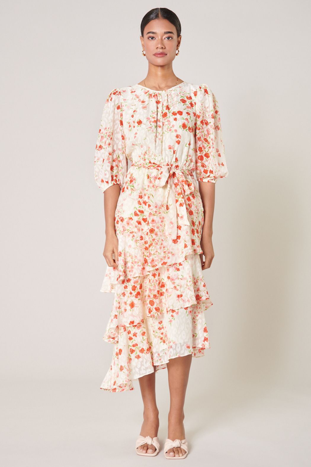 Blush pink floral midi dress with layered asymmetrical ruffles and waist tie