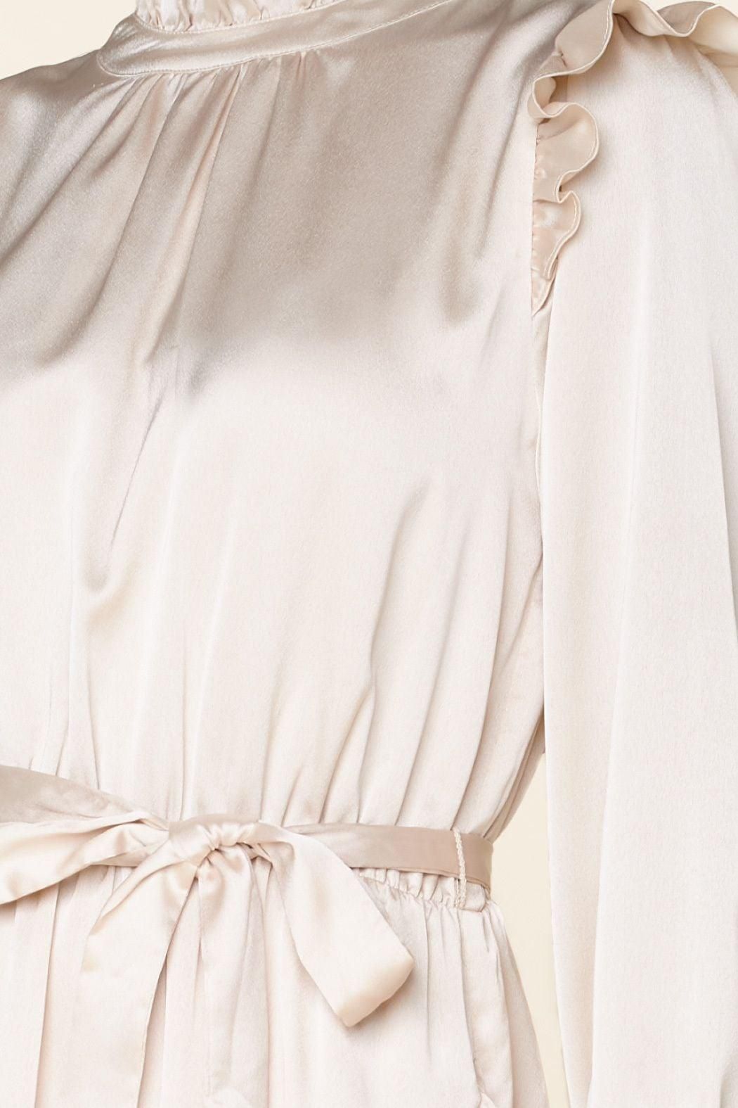 Close-up of champagne satin dress with balloon sleeves and asymmetrical flounce